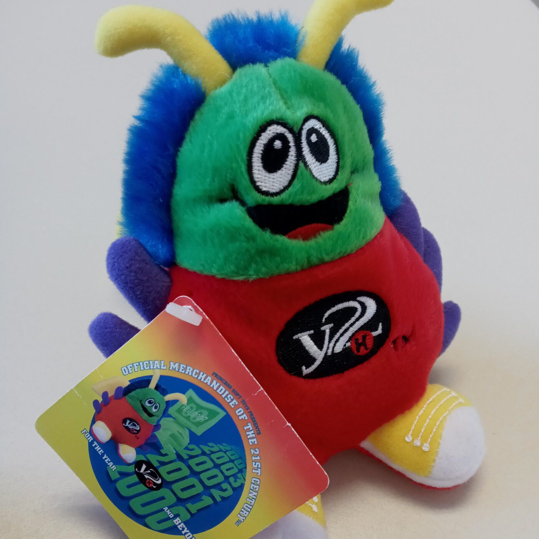 The Y2K "Bug": A colorful stuffed creature with antennae, fur, and goofy face. It says "Y2K" on the front.